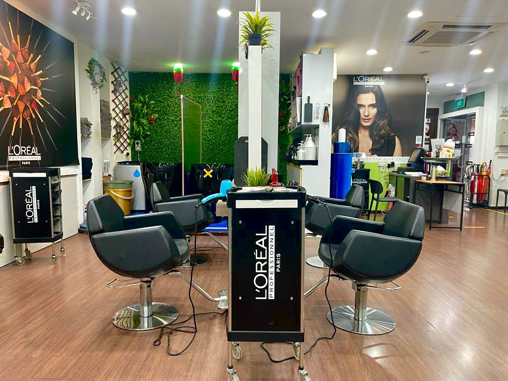 Styling chairs, L'Oreal Professionnel trolleys and a green foliage wall inside the salon
